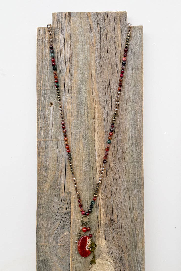 Suki fire agate necklace displayed on a wooden board