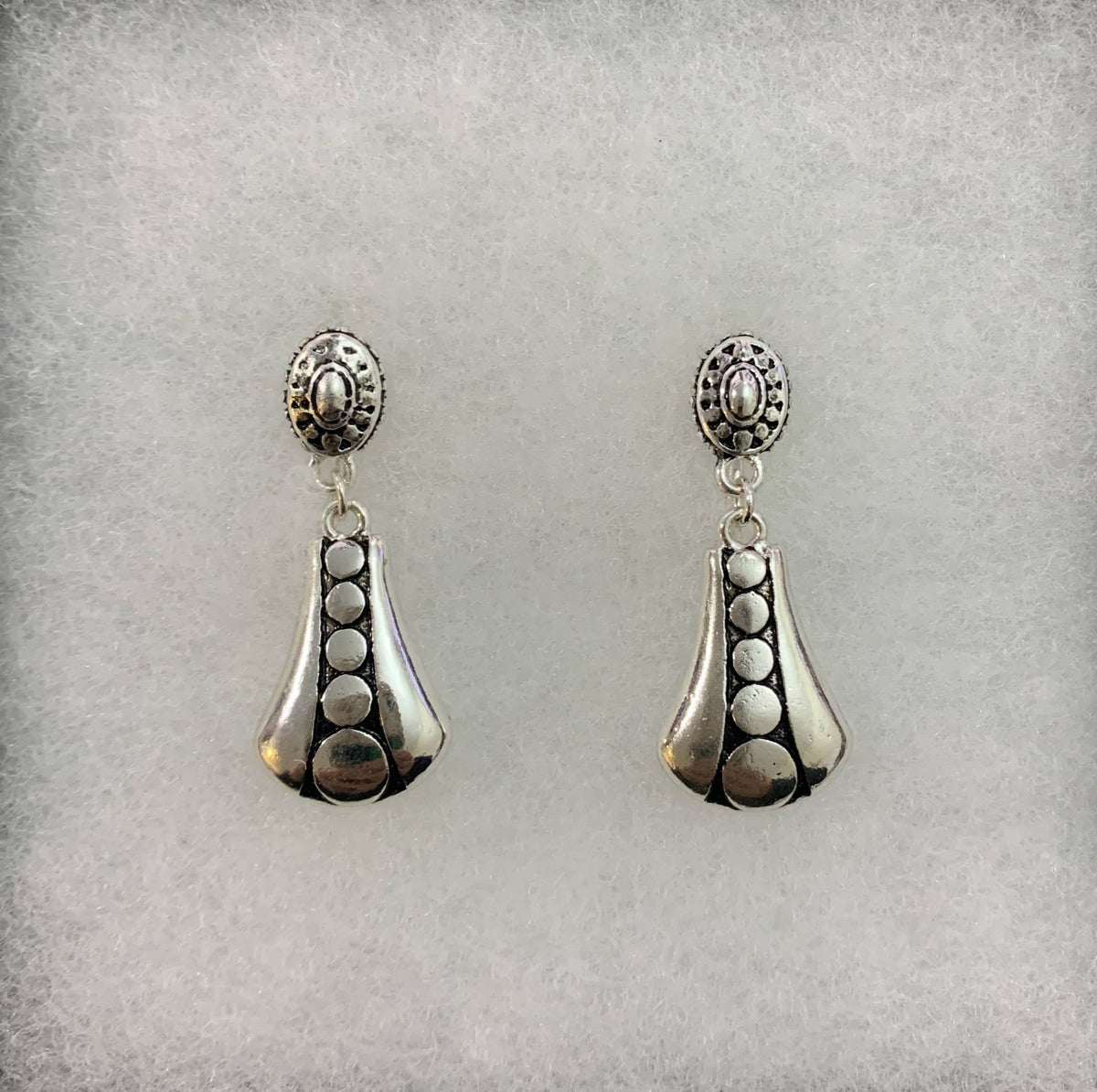 Clip-on circle earrings on a gray display