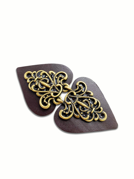 Dark brown pointed-oval clasp with ornate antique bronze filigree, closed, studio shot
