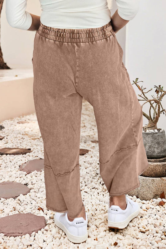 Side view of the buckskin cropped wide leg pants showing the elastic drawstring waist and exposed seams