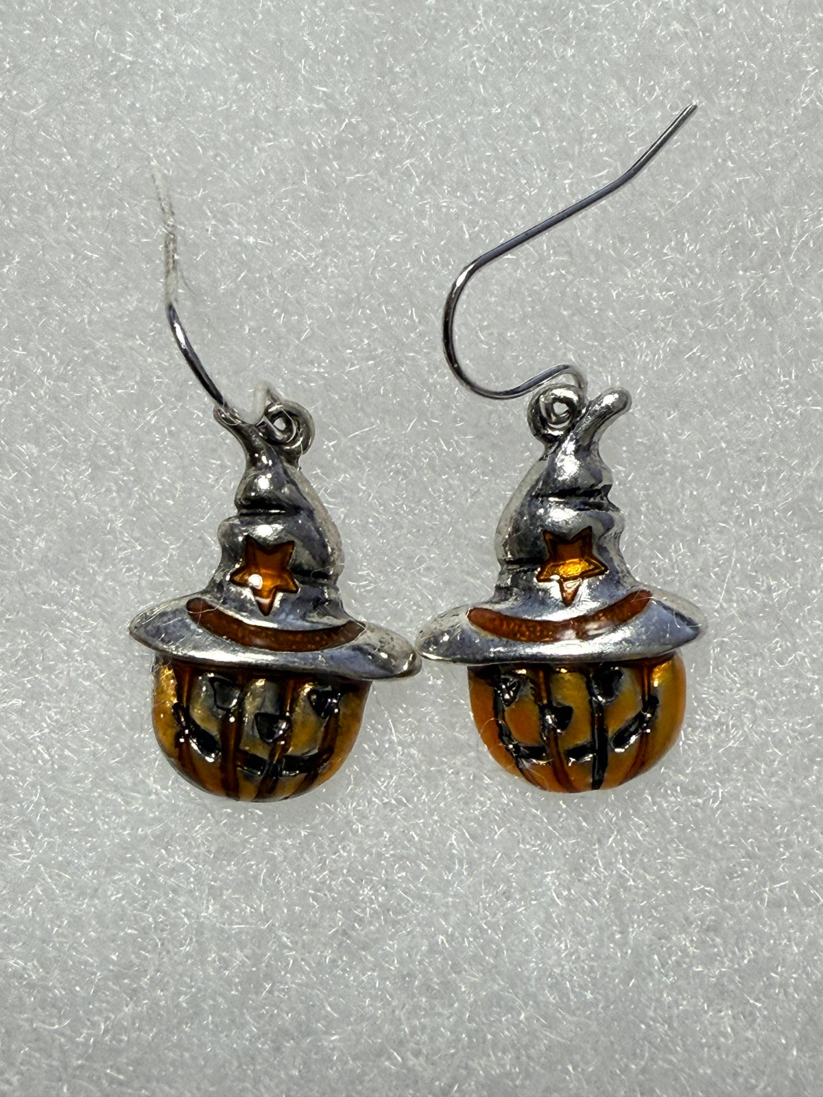 Pair of Halloween pumpkin earrings laid flat