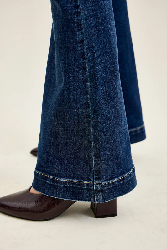 Close view of the flared hem of Judy Blue petite trouser flare jeans over brown boots