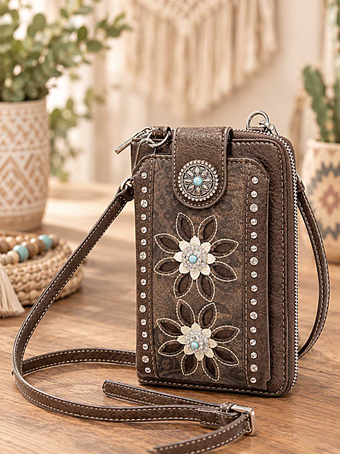 Brown crossbody wallet and phone holder with white floral cutwork, rhinestones and a turquoise-style clasp
