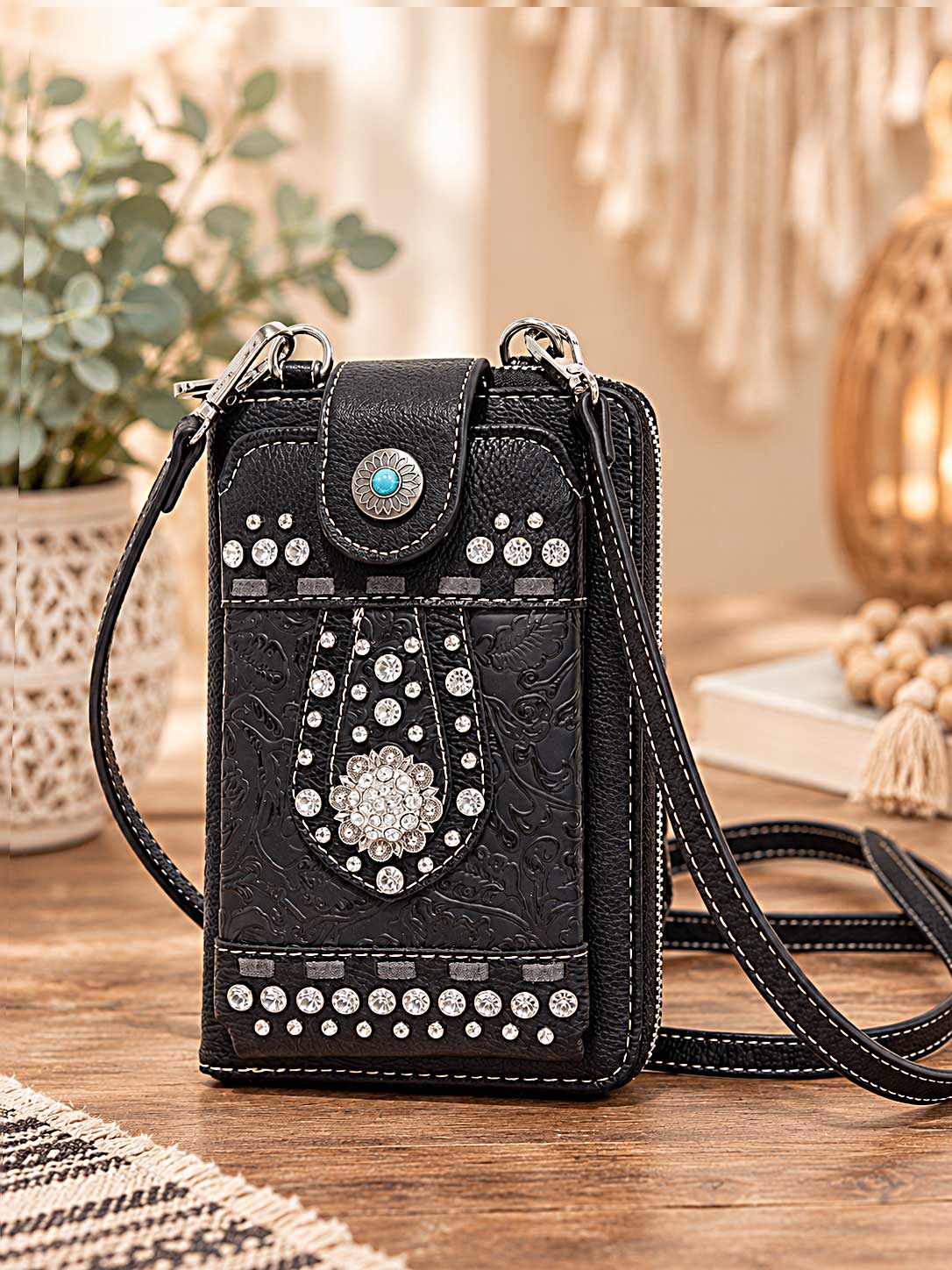 Black studded crossbody phone wallet with silver studs, crystals and a turquoise-style floral clasp