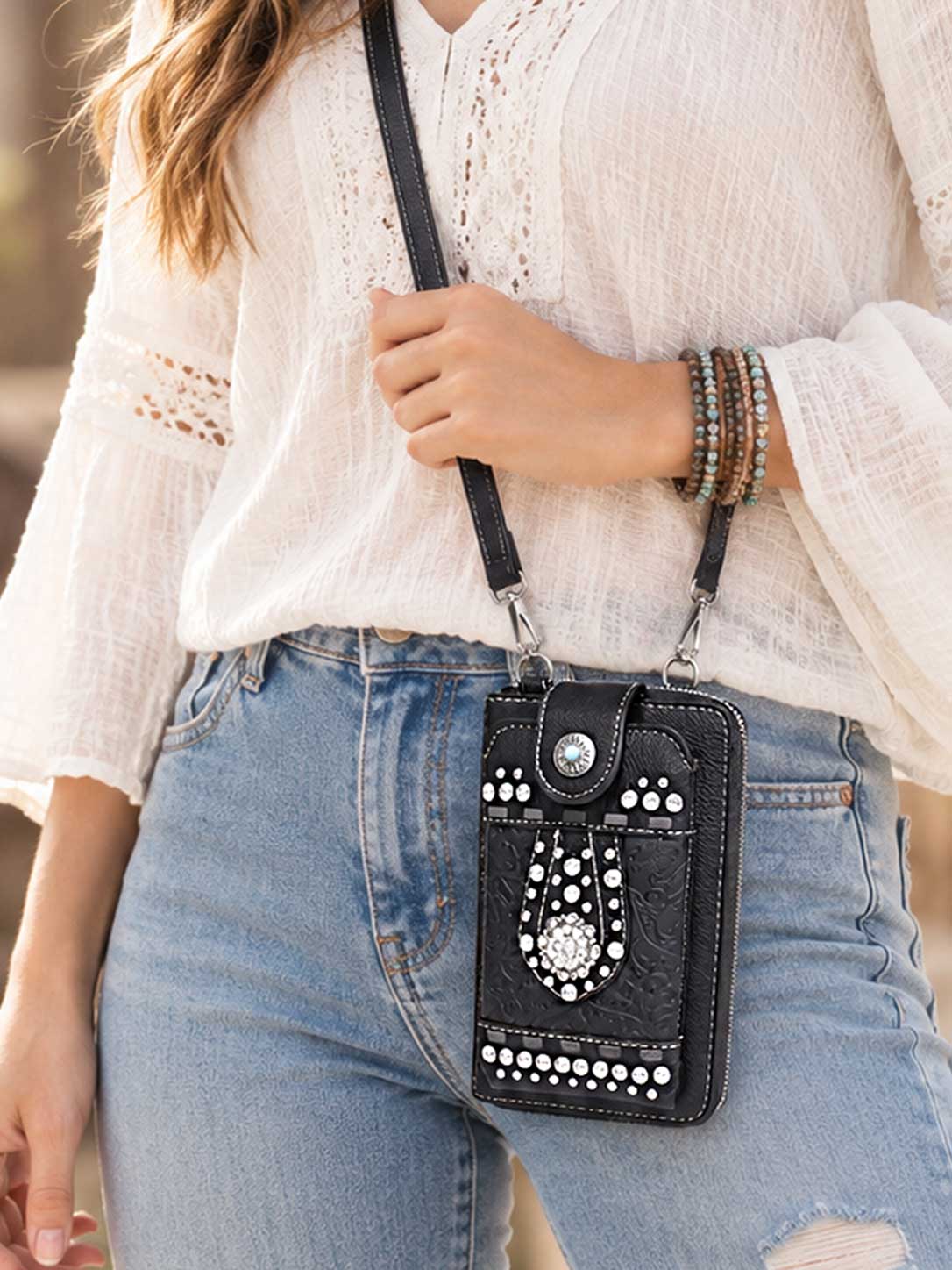 Model wearing the black studded phone wallet crossbody with jeans
