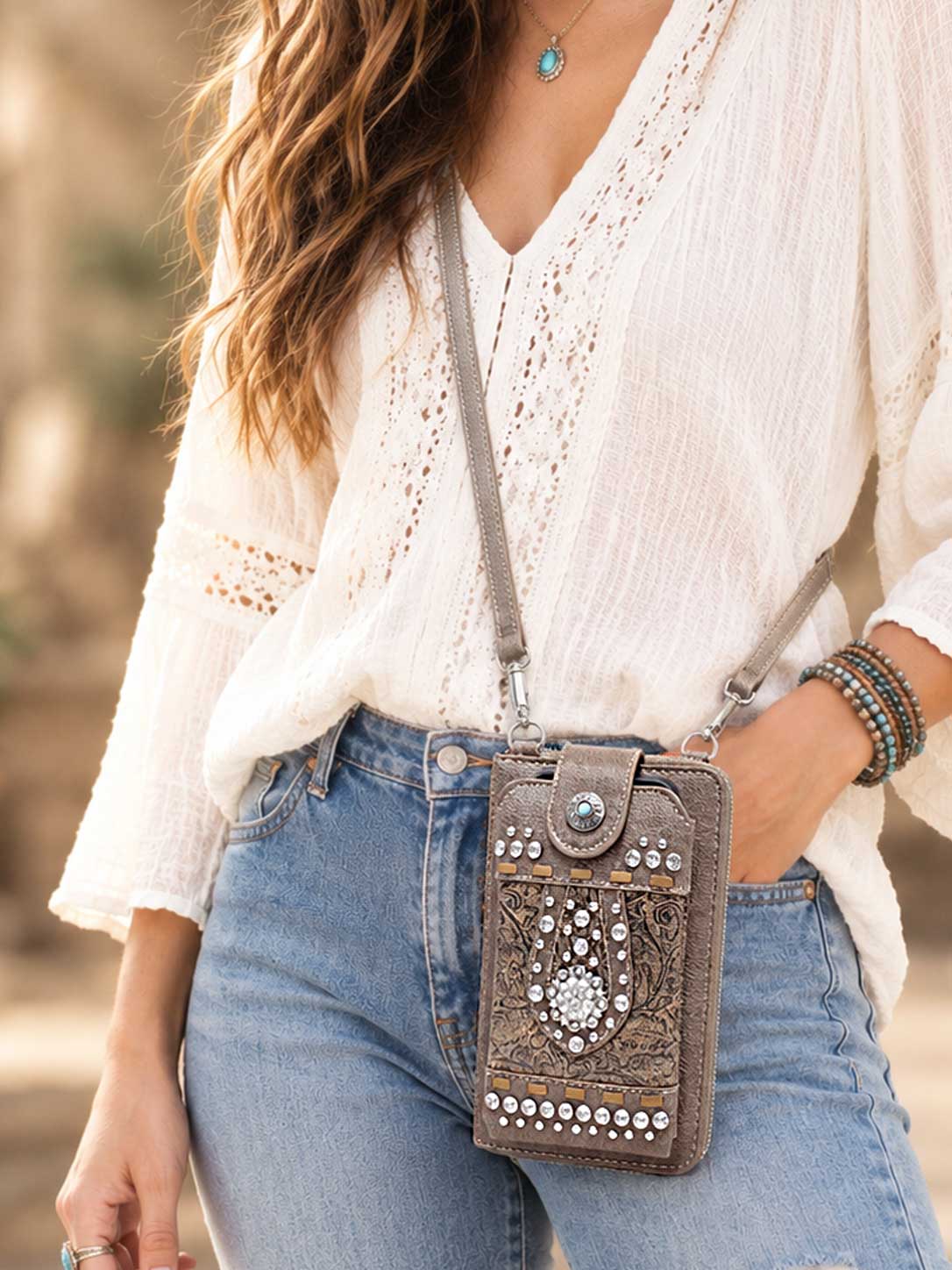 Model wearing the brown studded phone wallet crossbody over a white blouse