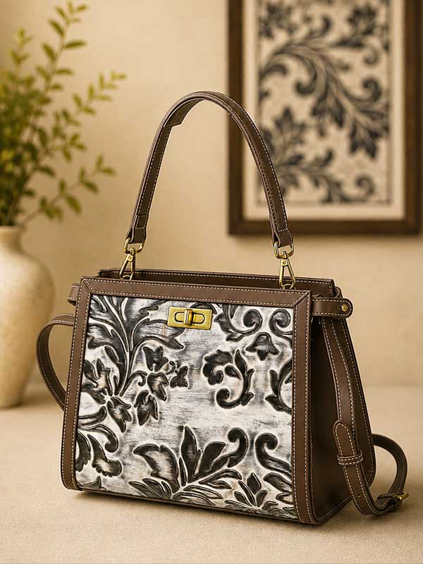 Mila chestnut brown satchel with a cream and black embossed floral and scroll front panel and gold-tone turn-lock