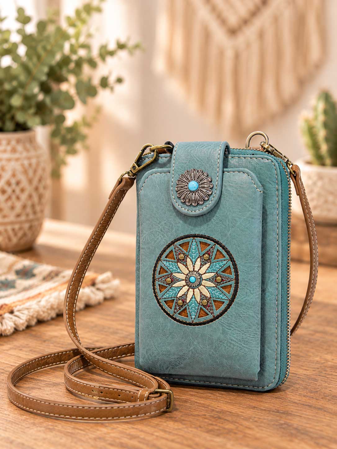 Turquoise crossbody phone wallet with an embroidered floral medallion and concho clasp; this listing is brown