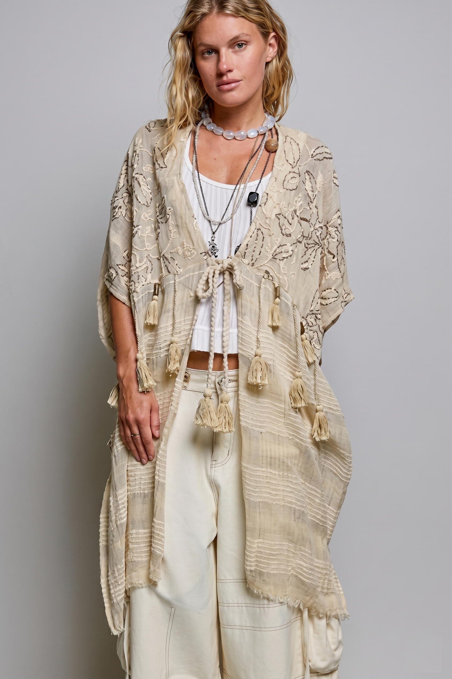Natural boho kimono with floral embroidery and a braided tassel tie, worn open over a white tank