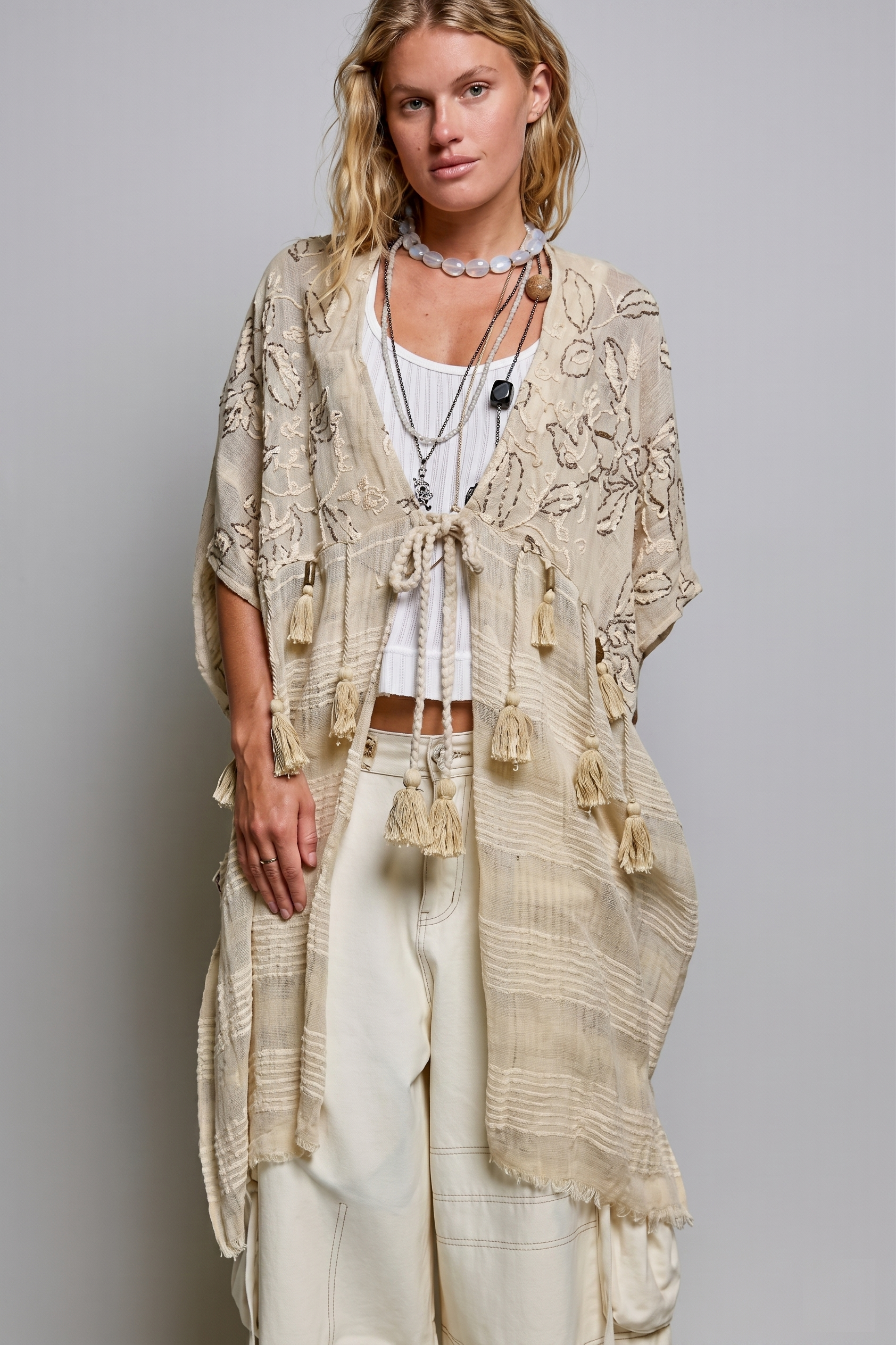 Natural boho kimono with floral embroidery and a braided tassel tie, worn open over a white tank