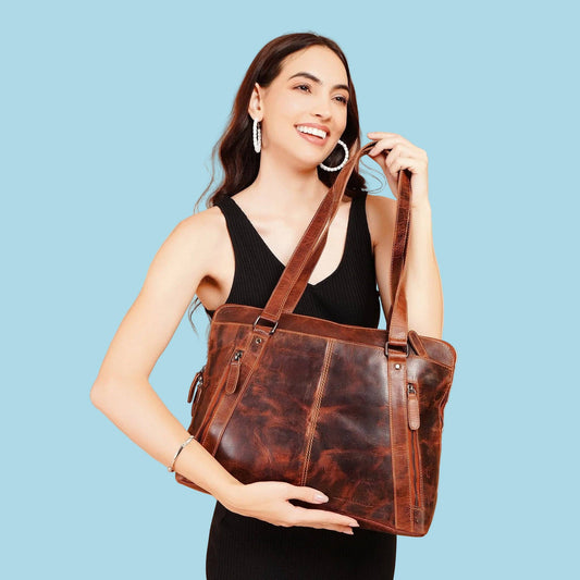 Woman holding the chestnut Camille leather laptop tote at her side