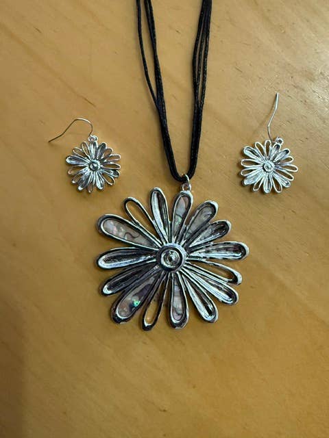 Daisy pendant set displayed on a wood surface