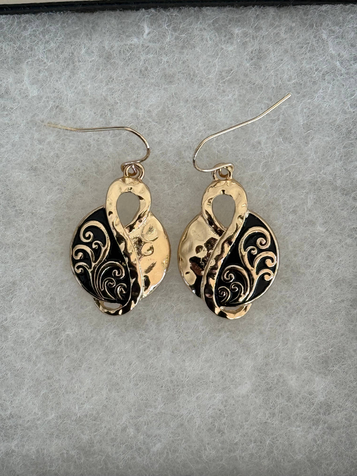 Infinity filigree earrings on a black display