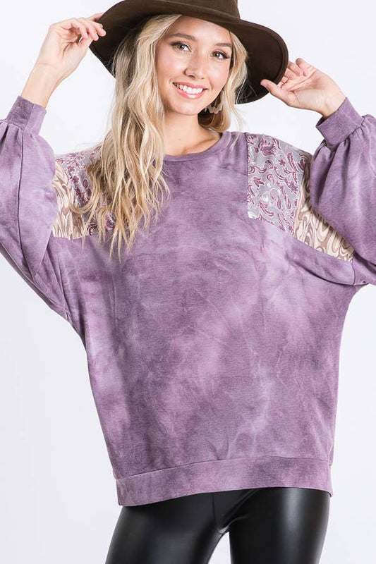 Woman in a purple tie dye top with bishop sleeves and printed shoulder panels