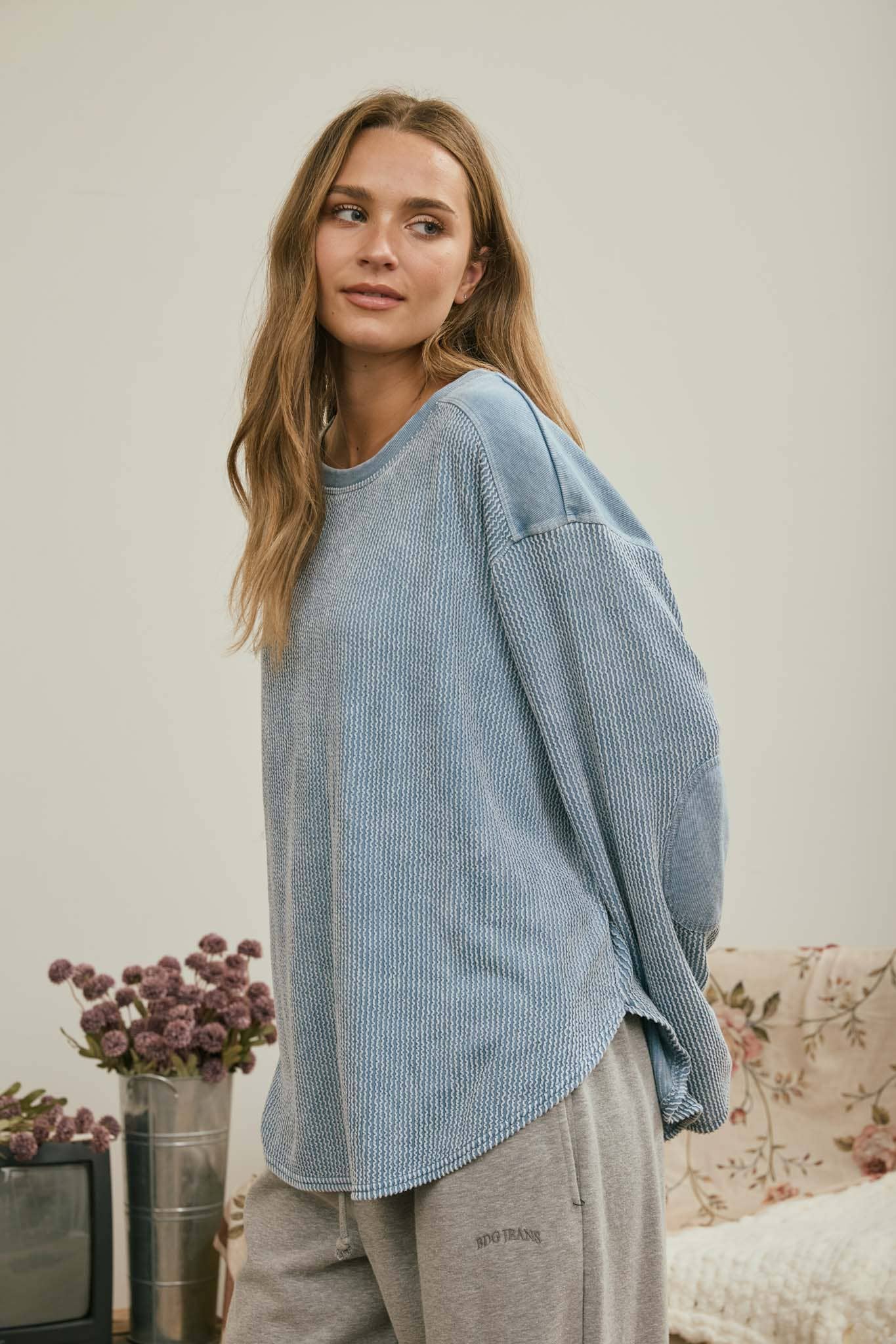 Side view of the light denim washed knit top