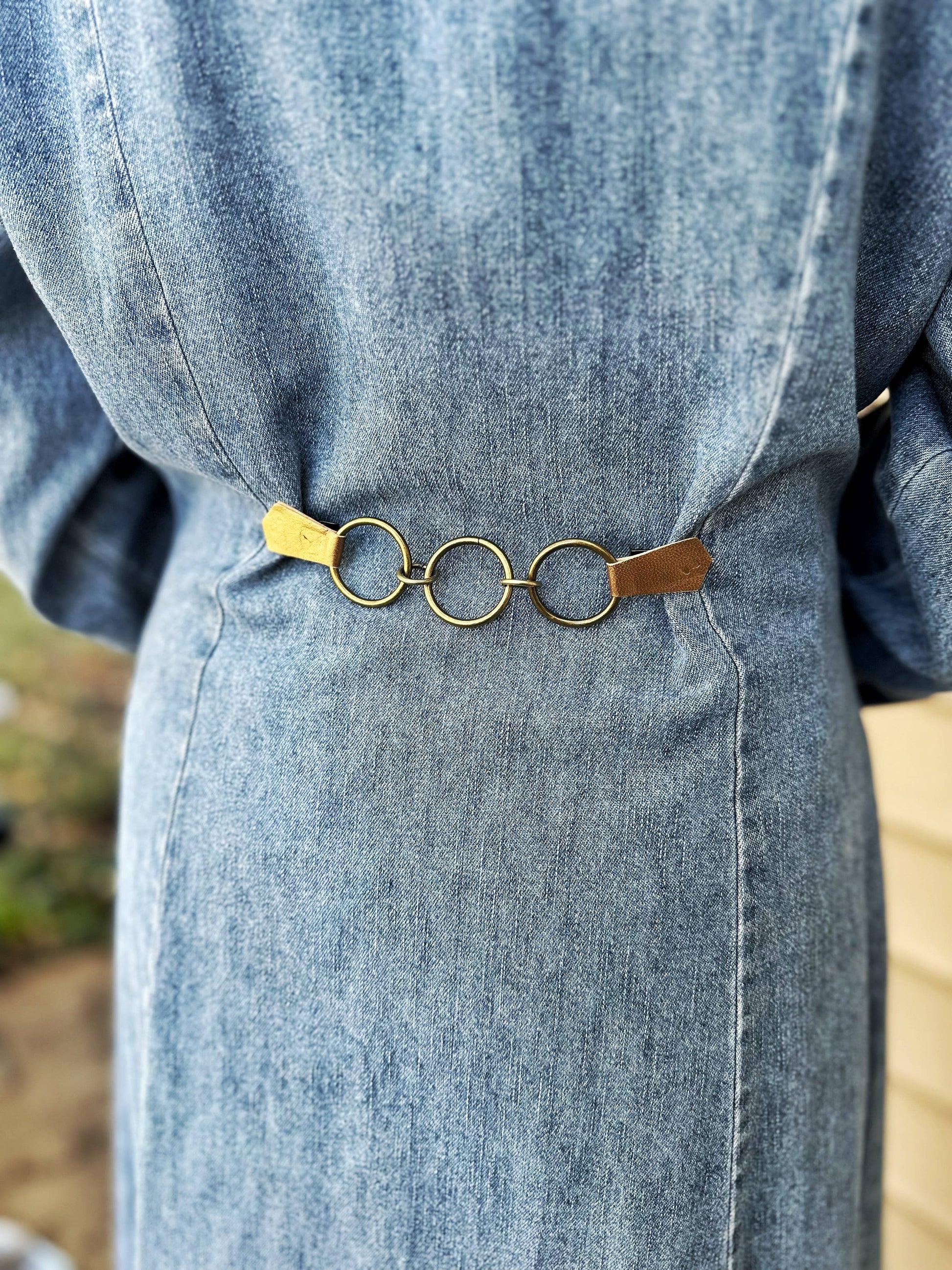 Back of a denim dress cinched with the gold rings clip