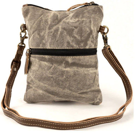 Back of the dragonfly passport bag showing the plain waxed canvas, the exterior zip pocket and the adjustable strap