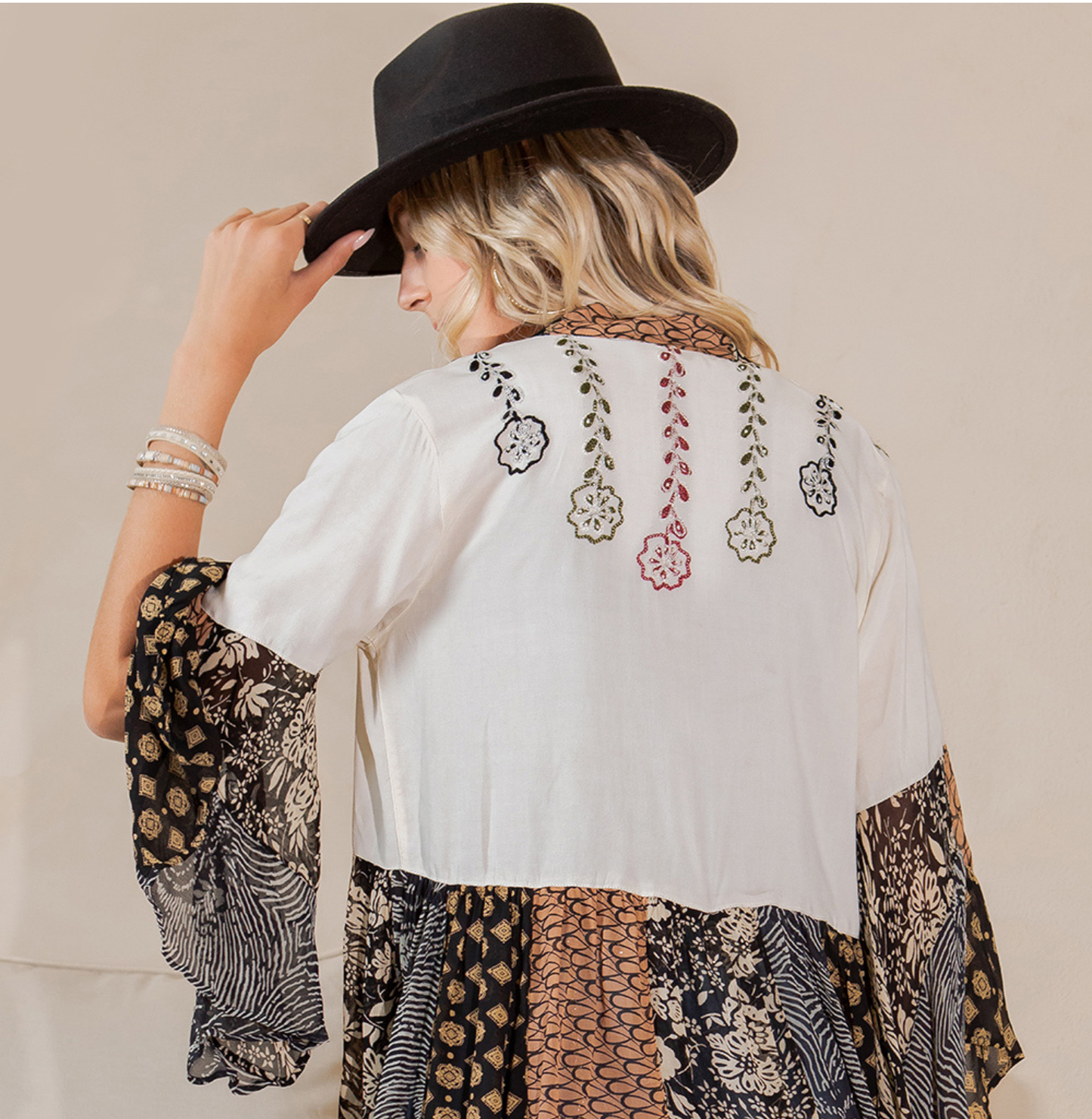 Back view of the pearl embroidered shrug showing floral vine embroidery and a patchwork lower band