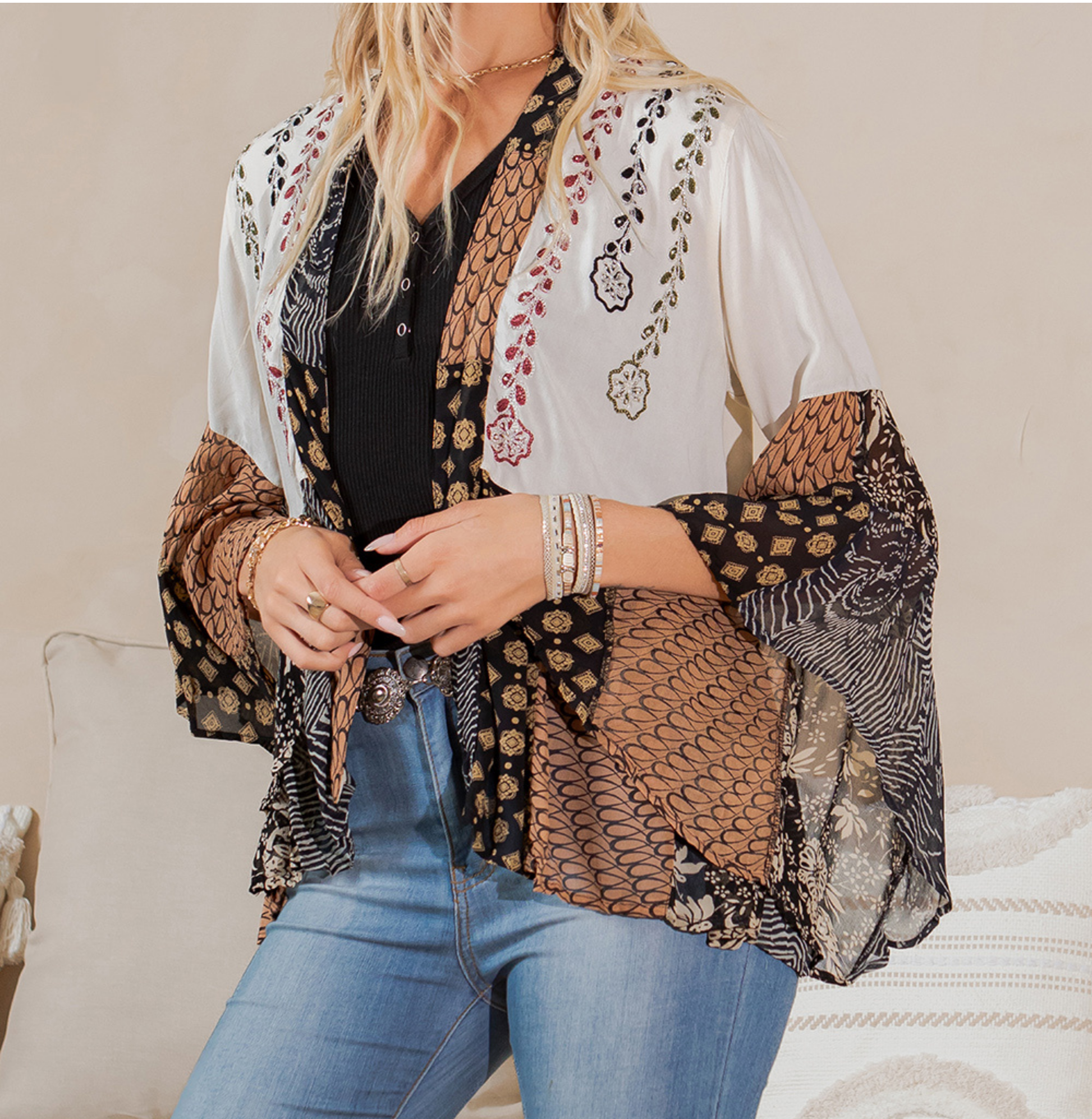 Close-up of the shrug's open front worn over a black top
