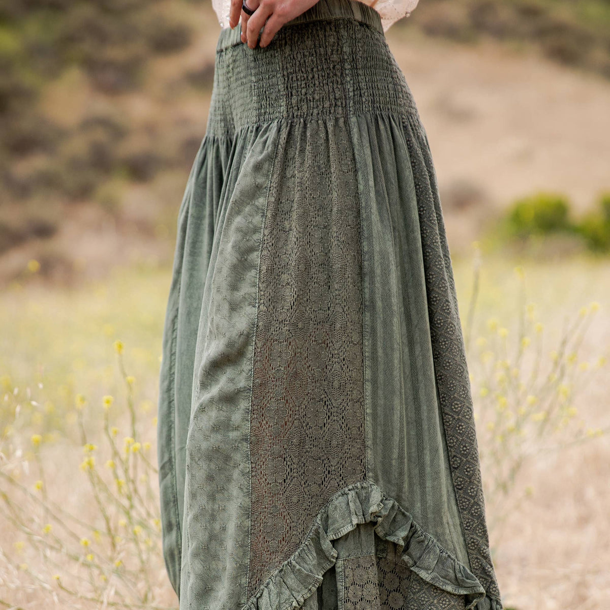 Close-up of the basil pants smocked waist, lace panel and ruffle