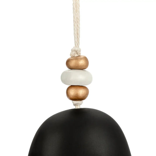 Close-up of the wooden and gold beads at the top of the black nativity holiday bell