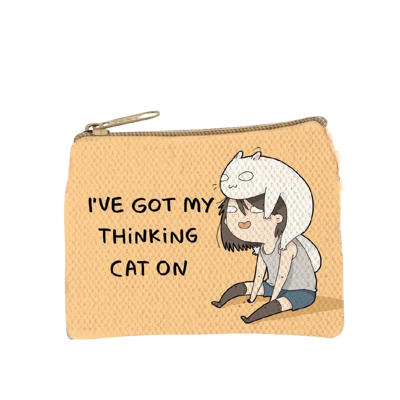 Warm tan zip coin purse printed with a woman at a desk and a cat sitting in her way, captioned I've got my thinking cat on