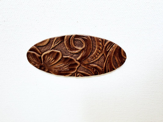 Close-up of the chocolate floral-embossed leather oval