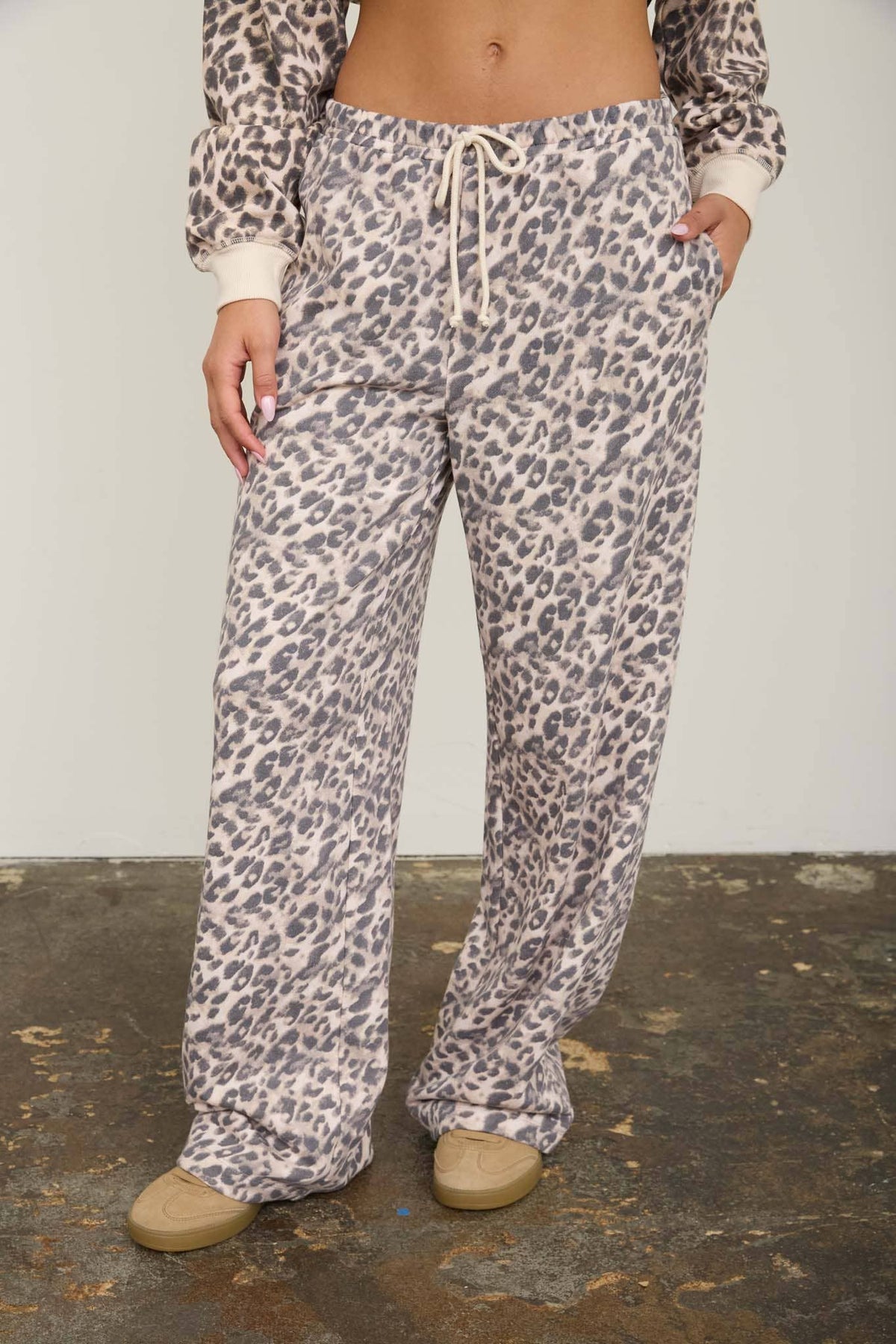 Model with a hand in the side pocket of the leopard lounge pants, showing the pocket placement