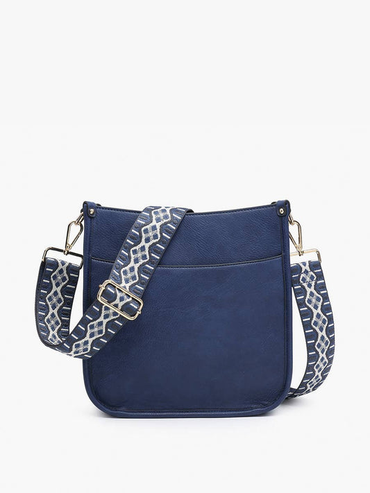 Navy vegan leather crossbody bag with top-zip closure and a removable guitar strap