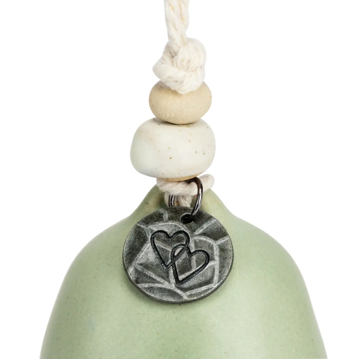 Close-up of the double heart medallion on the sage green Sister bell