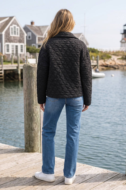 Back view of the black quilted snap front jacket worn with straight-leg jeans
