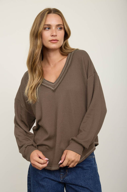 Woman in a mocha brown raw edge V-neck waffle knit top, front view