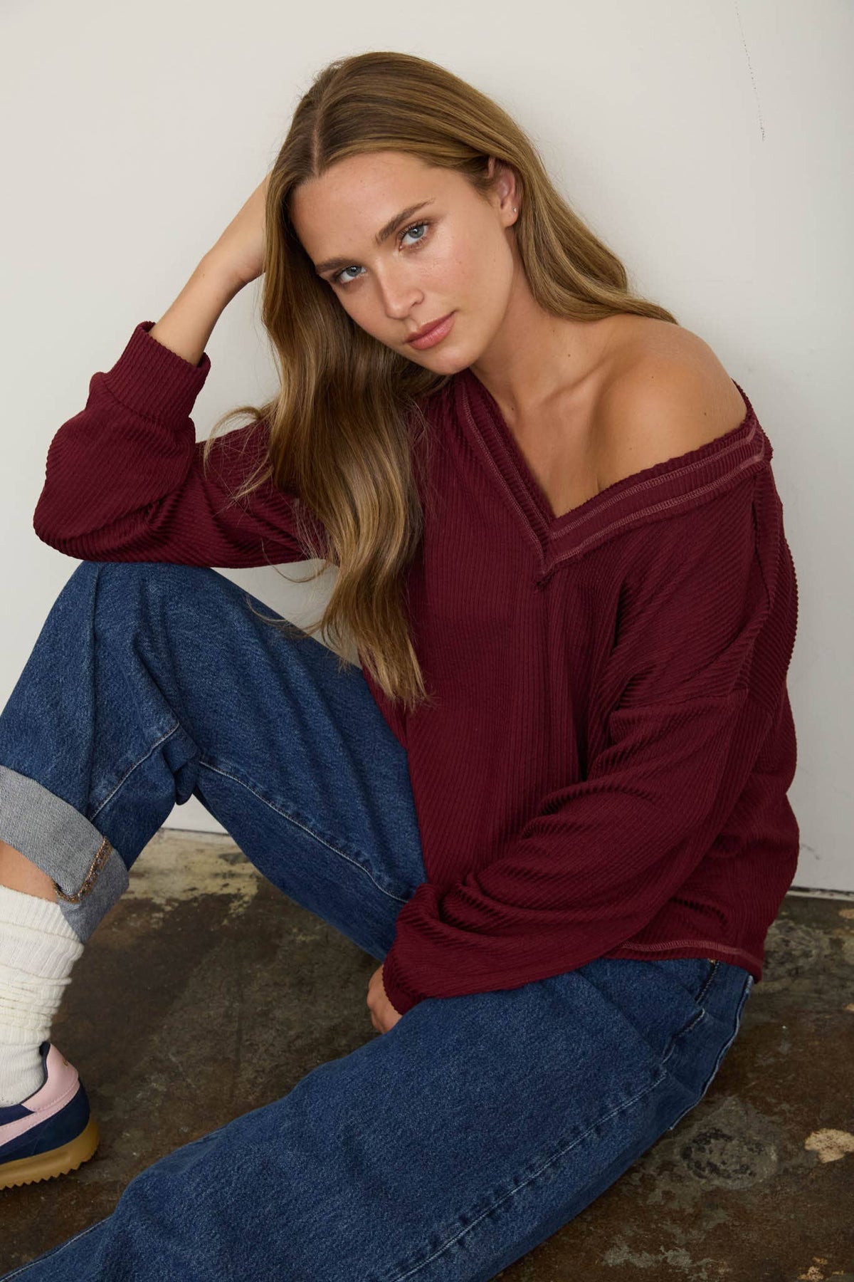 Model with an arm raised, showing the ribbed cuff and the loose fit through the sleeve