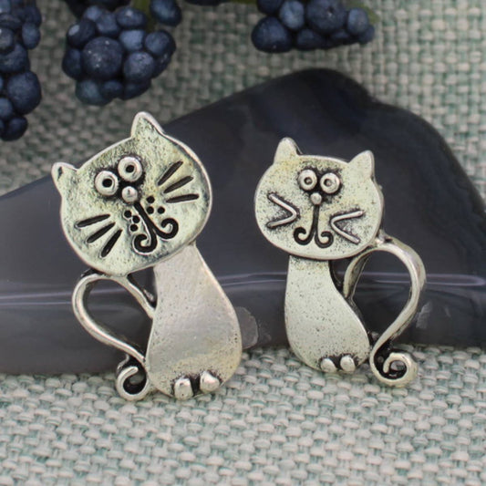 Pair of silver tone silly kitty cat post earrings standing on fabric