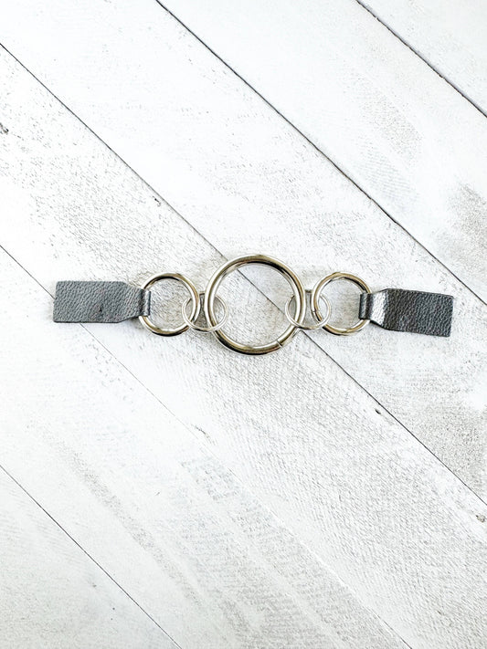 Top view of the silver ring cinch clip with gray leather tabs