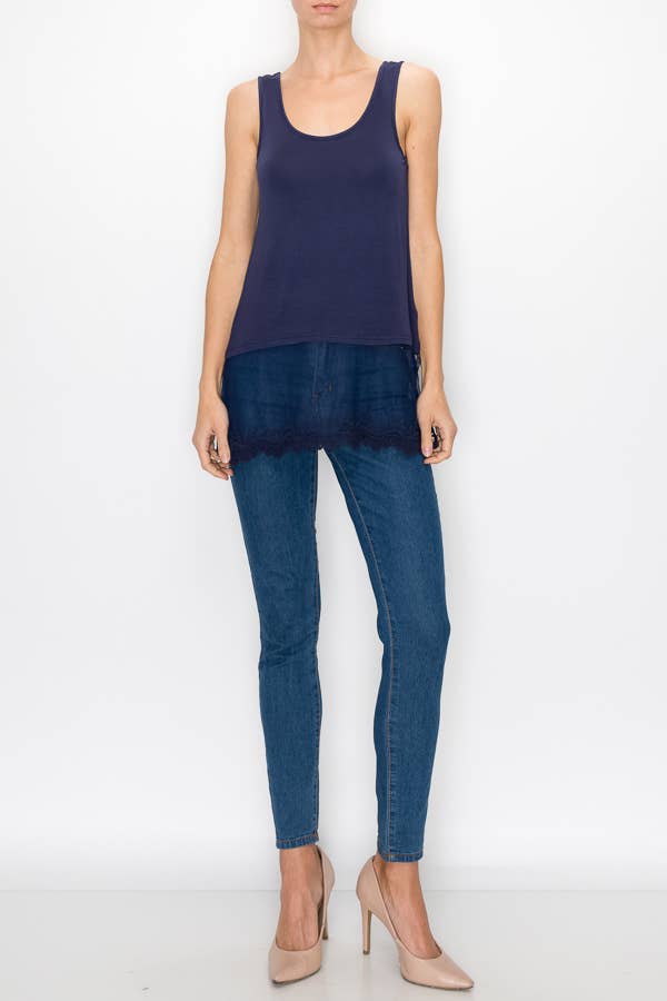 Model wearing a navy relaxed tank with a floral lace hem and jeans, front view