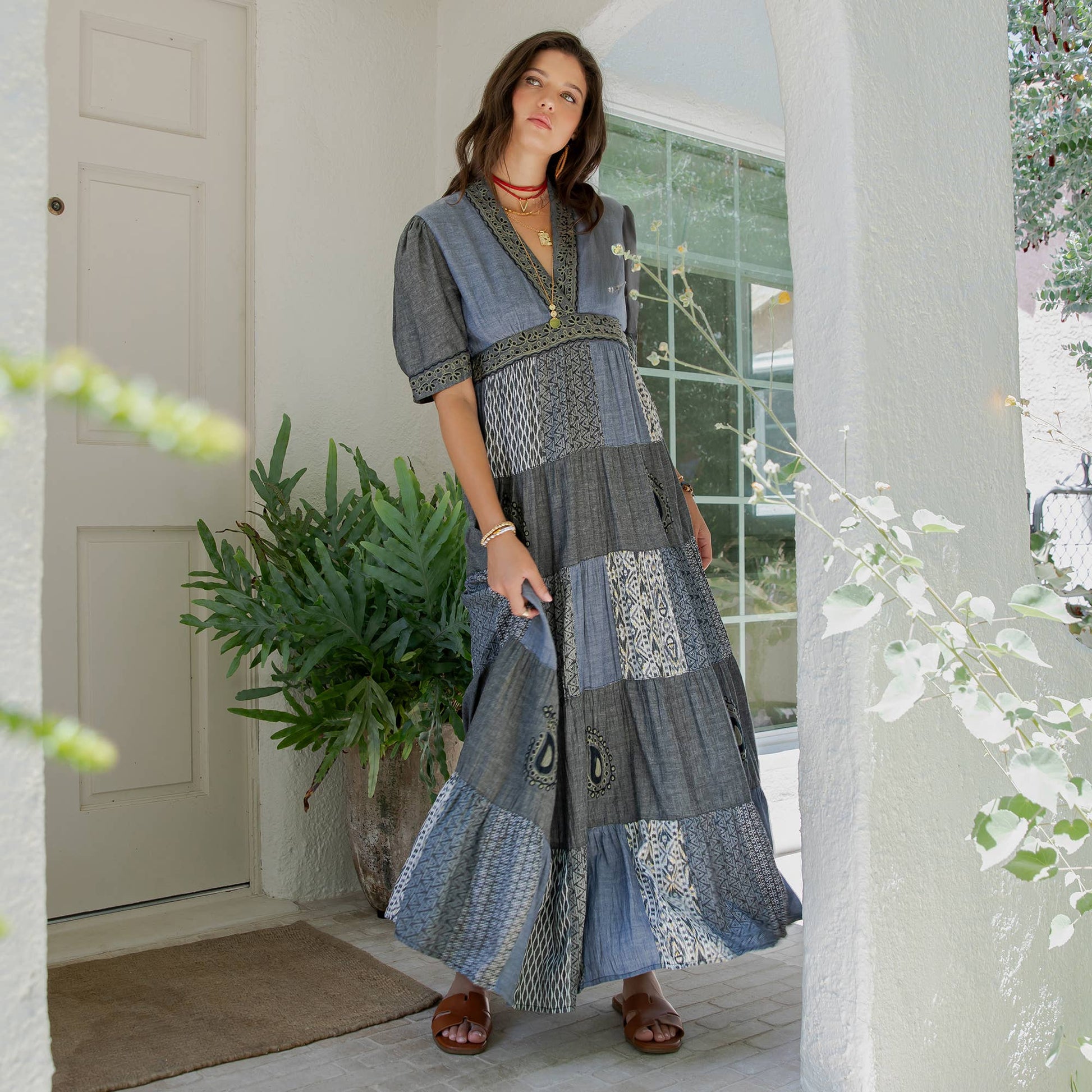 Model holding the tiered patchwork skirt of the chambray maxi dress