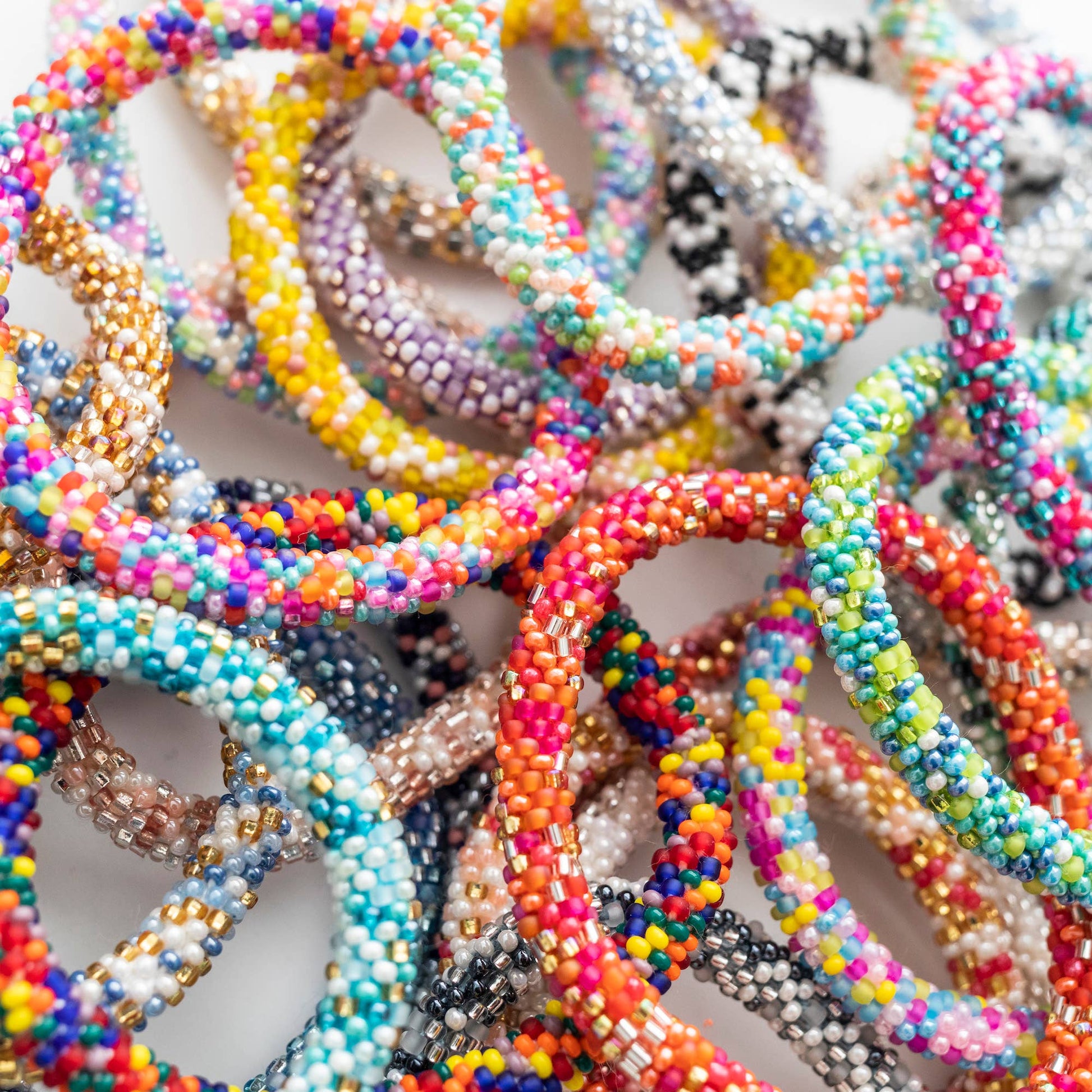 Close-up tangle of colorful glass bead roll-on bracelets