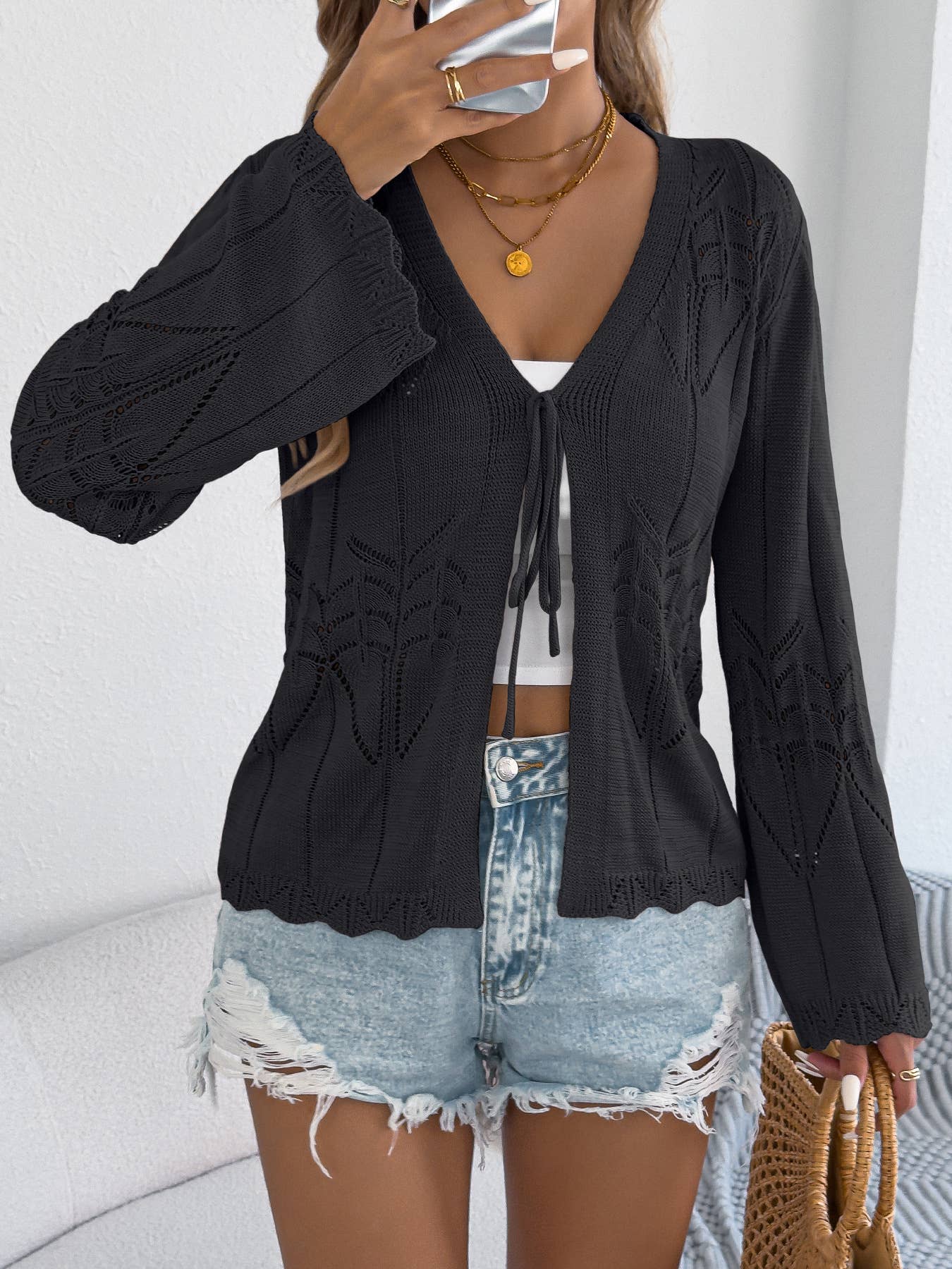 Black cardigan, front view with raised sleeve